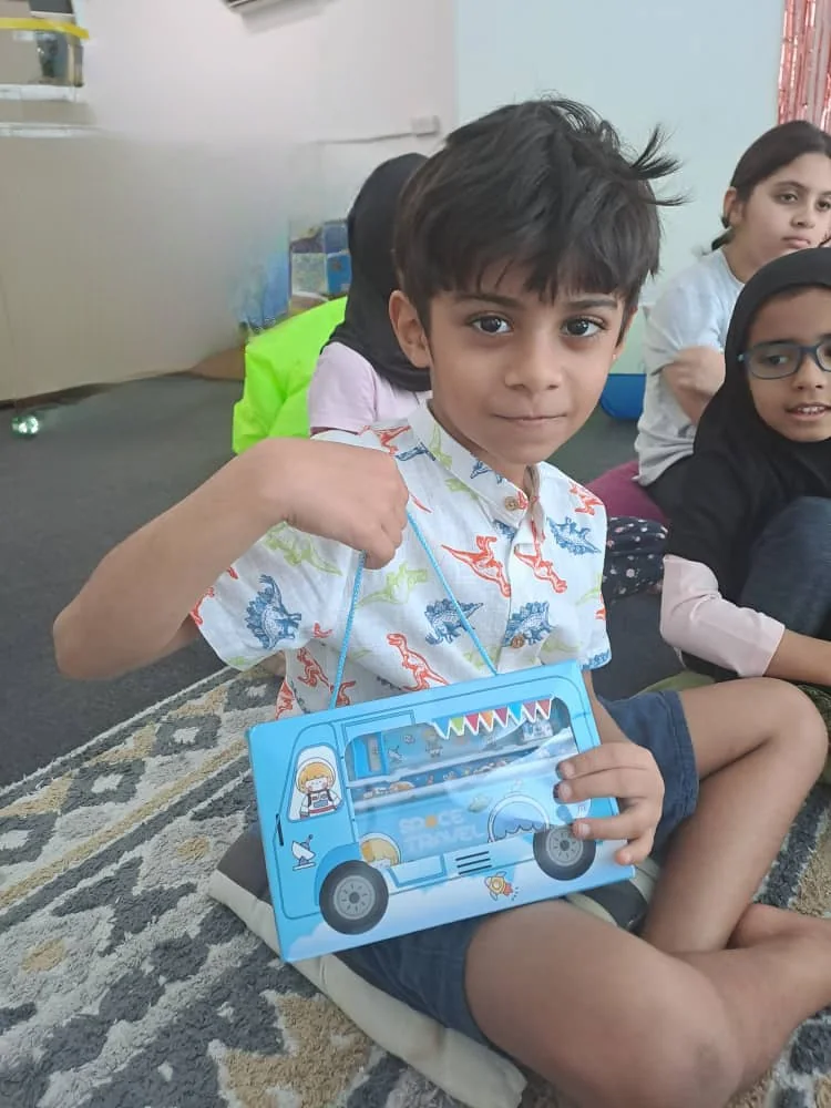 A learner with a Space Travel box from camp