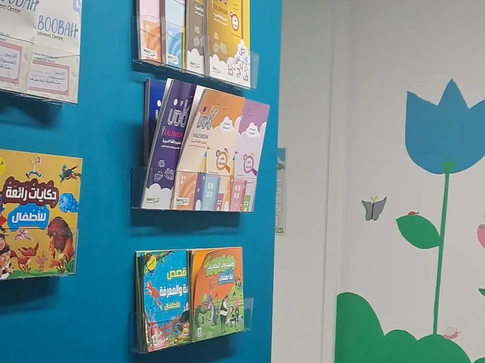 Arabic books on the blue wall, beside the tulip mural